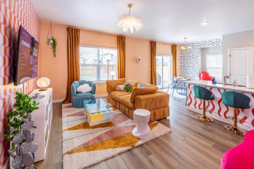 a living room with a couch and a kitchen at Near Airport, 3BR, Stock Tank Pool, Mini-Golf, Game Rm in Commerce City