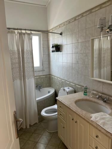 un bagno con un water, una vasca e un lavandino di Villa Erato a Rafina