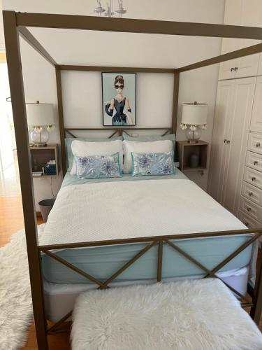 una camera da letto con un letto a baldacchino con cuscini blu di Villa Erato a Rafina