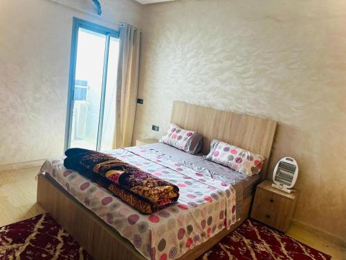 a bedroom with a large bed with a window at إقامة حسن in Fez