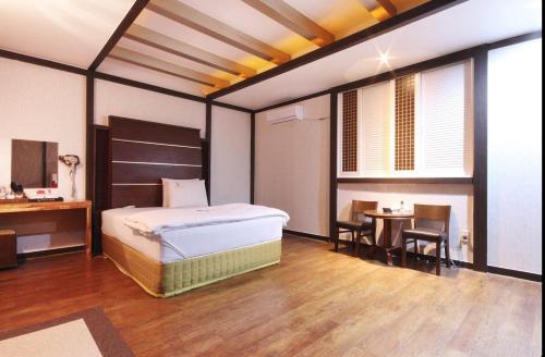 a bedroom with a bed and a table and chairs at Dongdaegu Leaders Hotel in Daegu