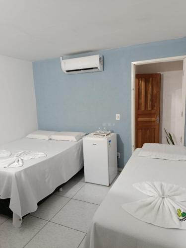 a room with two beds and a air conditioner at Hospedaria Temporarte in Piranhas