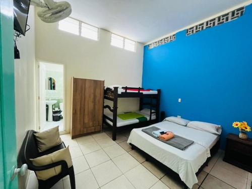 a bedroom with a bed and a blue wall at Hostal Colombia plaza in San Gil