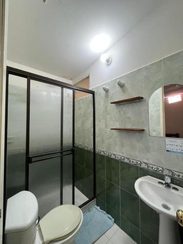 a bathroom with a shower and a toilet and a sink at Hostal Colombia plaza in San Gil