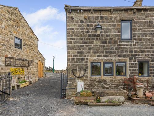 a brick building with a gate in front of it at The Barn in Keighley