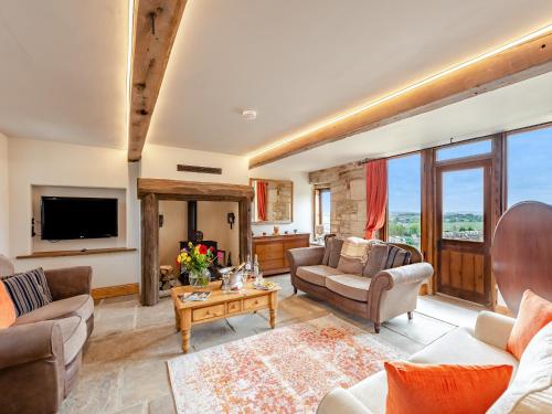 a living room with two couches and a tv at The Barn in Keighley