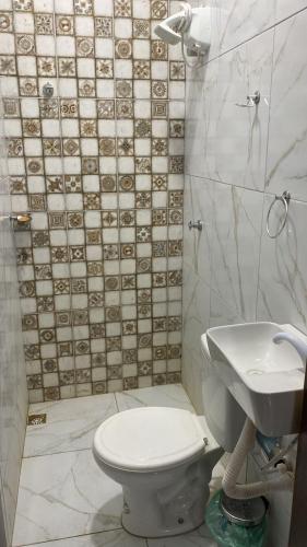 a bathroom with a toilet and a sink at Casa Aconchego in Japaratinga