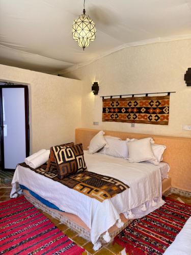 a bedroom with a bed and a chandelier at Royal Sands Camp - Erg Chigaga Luxury Camp in Mhamid
