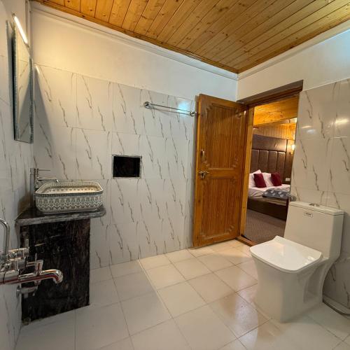 a bathroom with a toilet and a sink at The VILLAGE RESORT ASHUNA in Kargil