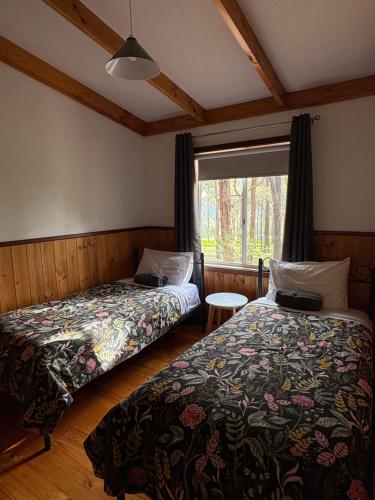 a bedroom with two beds and a window at Balingup TimberTop Cottages in Balingup