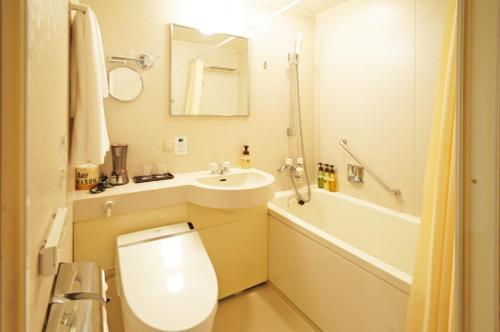 a bathroom with a toilet and a sink and a tub at Chisun Hotel Kamata in Tokyo