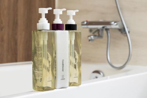 two bottles ofodorizers sitting on a bathroom sink at Richmond Hotel Aomori in Aomori