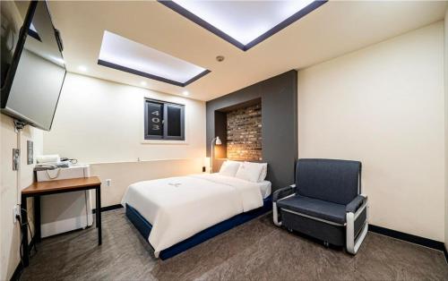 a hotel room with a bed and a chair at Daily Motel in Incheon