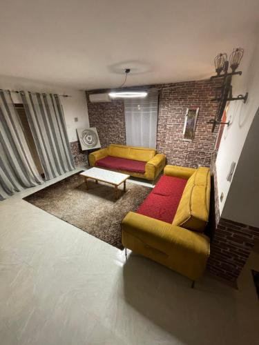 a living room with a yellow couch and a brick wall at House in Center in Skopje