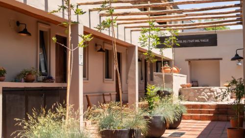 a building with trees and plants in a courtyard at Hotel Boutique con Desayuno in Tafí del Valle