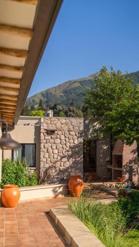 a house with a stone wall and a patio at Hotel Boutique con Desayuno in Tafí del Valle