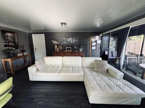 a living room with a white couch in it at Modern waterfront chalet in Geel