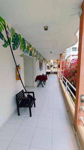 a hallway with a bench and a room with flowers at frente al mar Hotel La Morena in Taganga