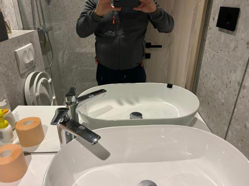 a man taking a picture of a bathroom sink at Marepromo Jezera 1 in Jezera