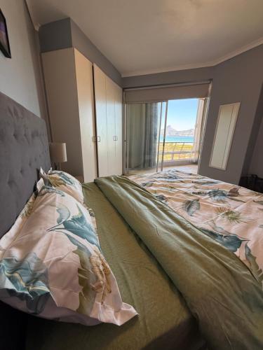 a bedroom with a large bed with a large window at Cozy Apartment with Table Mountain and beach views in Cape Town