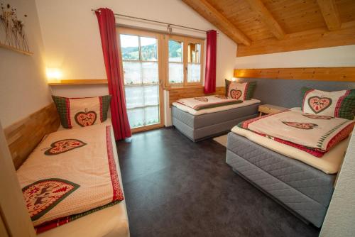 a room with two beds and a window at Traumferienwohnung Alpenliebe Sommer-Hörnerbahnen kostenlos in Bolsterlang
