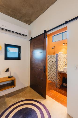 a bathroom with a wooden door and a sink at Olivo in San Carlos