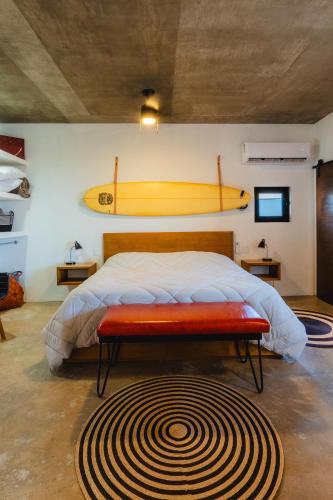 a bedroom with a bed with a surfboard on the wall at Olivo in San Carlos