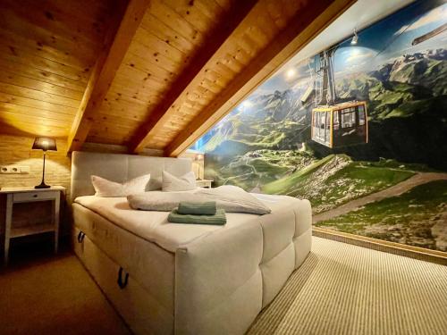 a bedroom with a large painting on the wall at Ferienhaus ALPVERLIEBT Sommer-Hörnerbahnen kostenlos in Bolsterlang