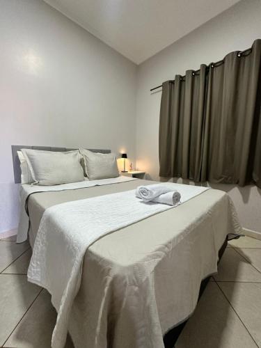 a bedroom with a large bed with a towel on it at maray house complete elegance very well located in Formosa