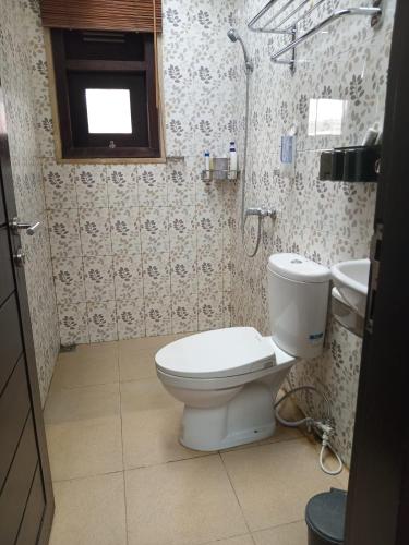 a bathroom with a toilet and a sink at Homestay Mroom Bali in Perean
