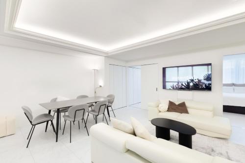 a white living room with a table and chairs at City Hotel Namba Prime in Osaka