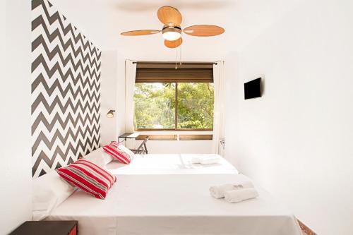 a white bedroom with a bed and a window at Fira Guest House in Barcelona
