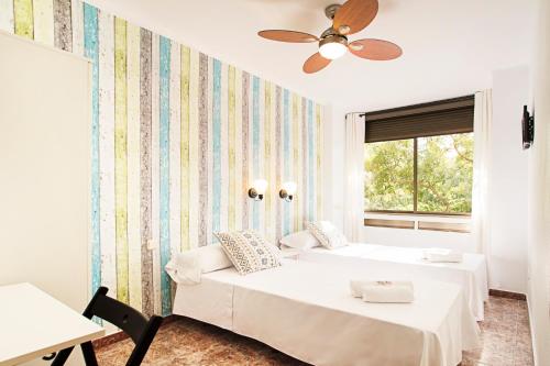 1 dormitorio con 2 camas y ventana en Fira Guest House, en Barcelona