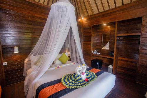 a bedroom with a bed with a canopy at Samanta Huts in Nusa Lembongan