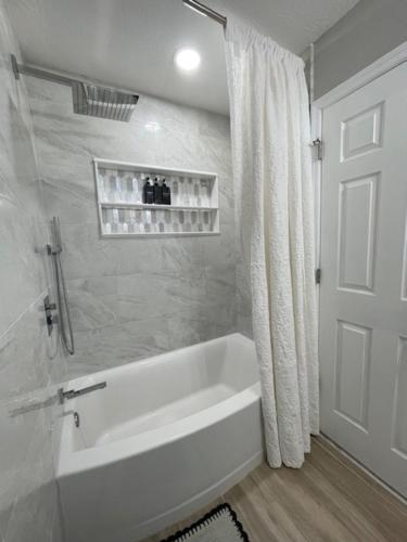 a white bathroom with a tub and a shower at Beautiful house in Augusta in Augusta