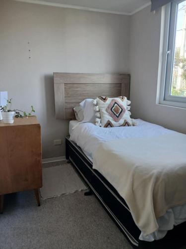 a bedroom with a bed and a dresser and a window at CasaNativa 7Sur in Curicó
