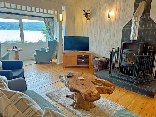 a living room with a coffee table and a fireplace at The Heron in Ardentinny
