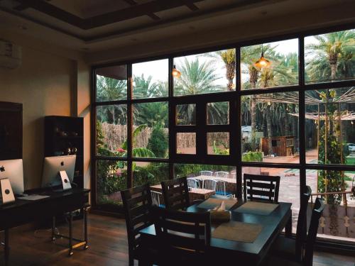 a dining room with a table and a large window at Mabiti hotel in Al-ʿUla