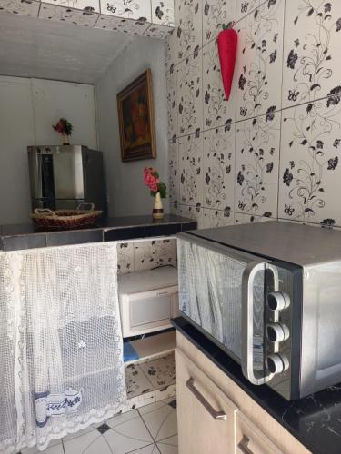 a kitchen with black and white wallpaper and a microwave at Lar da Dona Judite in Pontal do Paraná