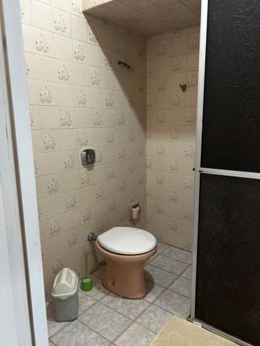 a bathroom with a toilet in a small room at Pousada Pampeano in São Gabriel