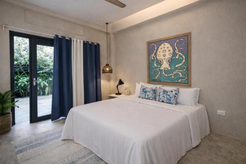 a bedroom with a white bed and a large window at Sleepy Gypsea Villa Siargao in Siargao Island