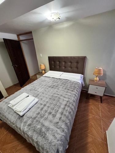 a bedroom with a large bed with two towels on it at Santa Ana Home Cusco in Cusco
