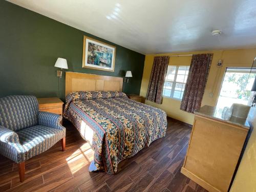 a hotel room with a bed and a chair at Shangri La Motel in Ocala