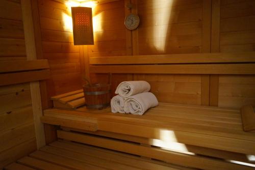 a sauna with two rolled towels and a clock at Hotel Alpenrose in Rodengo