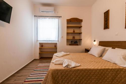 a bedroom with a bed and a window at Casa de Flores 2 in Plaka Milou