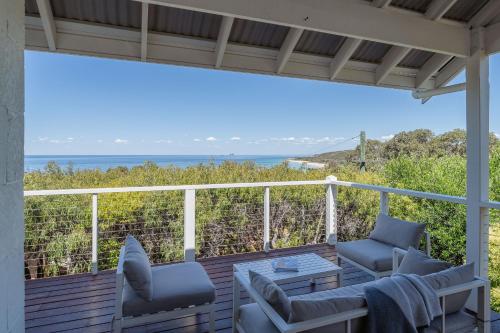 a deck with chairs and a table and a view of the ocean at Sea Spell I Private Properties in Dunsborough