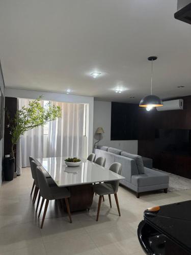 a living room with a table and a couch at Sublime Mognos Apartment - Bosque Saúde in Cuiabá