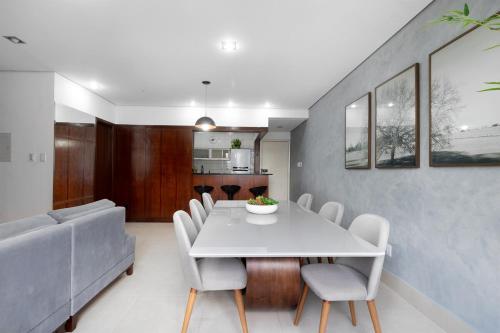 a dining room with a white table and chairs at Sublime Mognos Apartment - Bosque Saúde in Cuiabá
