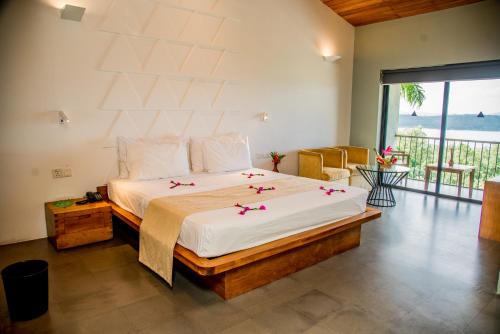 ein Schlafzimmer mit einem großen Bett, das mit Blumen bedeckt ist in der Unterkunft Lavendish Lake Giritale - Former Giritale Hotel in Polonnaruwa
