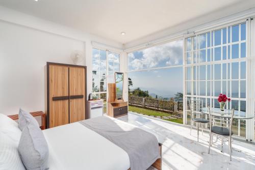 a bedroom with a bed and a large window at Villa Rosaria - Framed by Nature, Finished with Luxury in Beragala